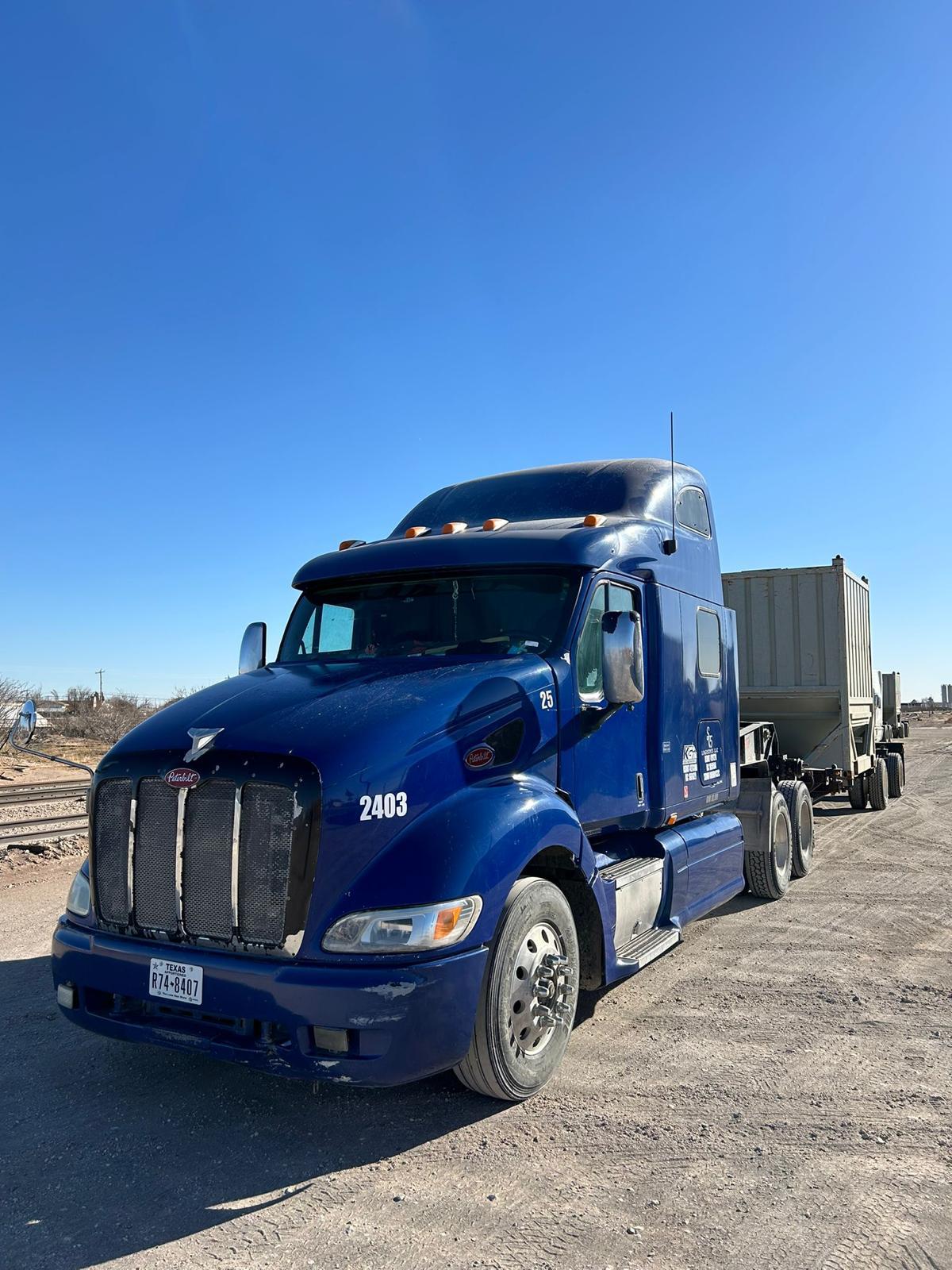 Blue Peterbilt 2403 on a desert oilfield site